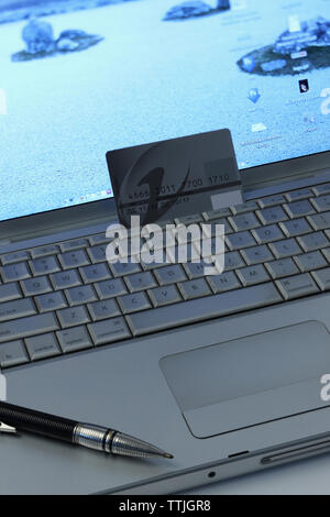 Credit card with a pen on a laptop Stock Photo