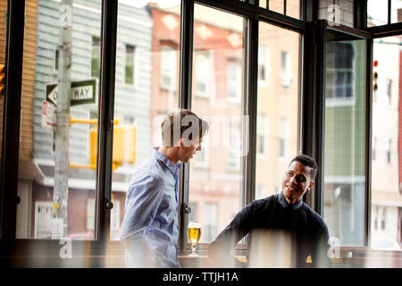 Male friends talking in bar Stock Photo