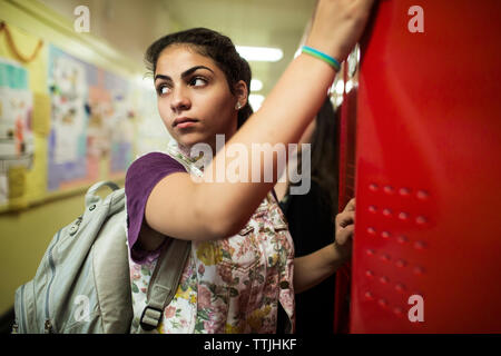 Woman looking away while standing in locker room Stock Photo
