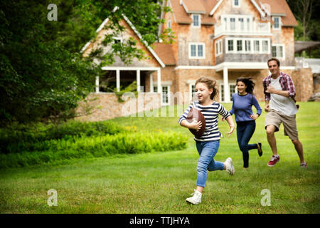 Family playing football in lawn Stock Photo