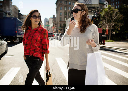 Woman with shopping bags crossing road in city Stock Photo