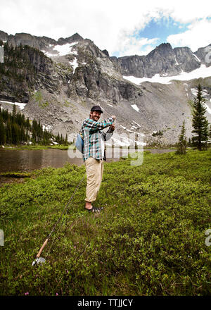 Close up view of back tourist woman brown backpack and fishing rod