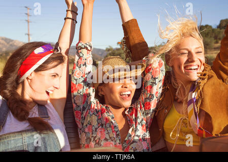 Cheerful friends looking away while sitting in convertible car Stock Photo