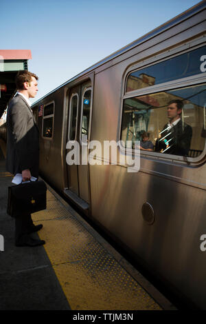 businessman looking at train arrived on railroad track Stock Photo
