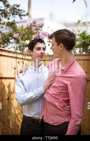 Affectionate gay couple standing in backyard Stock Photo
