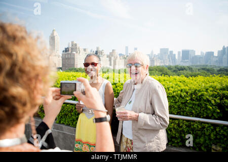 Cropped image of woman photographing friends Stock Photo