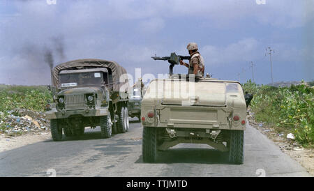 5th November 1993 Heading north, towards Mogadishu, Somalia, an American soldier mans an M60 machine gun on top of his Humvee as it passes a Pakistani United Nation convoy. Stock Photo