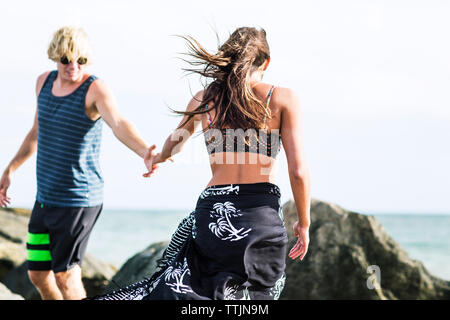 Couple walking on shore at beach Stock Photo