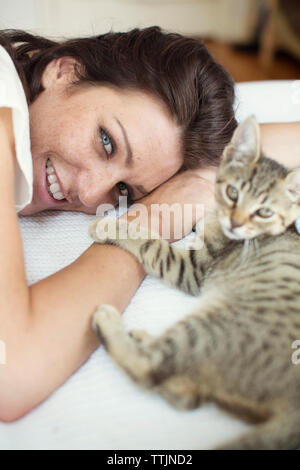 Portrait of woman with cat relaxing on bed at home Stock Photo