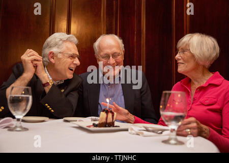 Happy senior friends sitting in restaurant Stock Photo