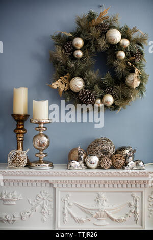 Christmas wreaths hanging on wall over mantelpiece