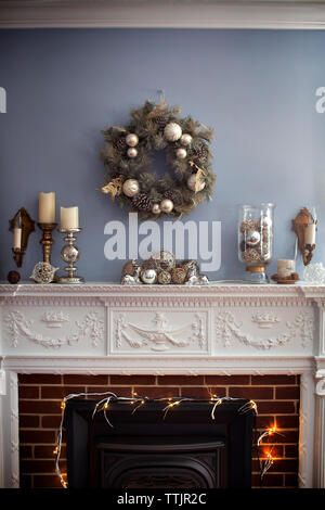 Christmas wreaths hanging on wall over fireplace Stock Photo