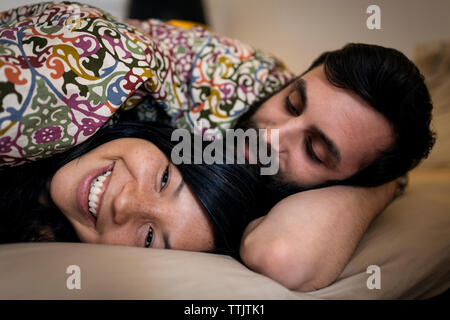 Happy couple relaxing on bed at home Stock Photo