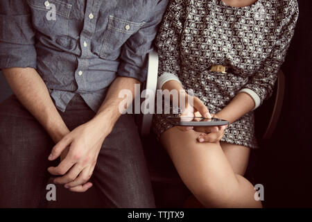 Midsection of couple sitting in bus Stock Photo