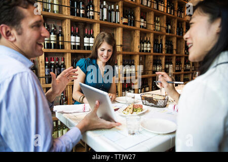 businessman showing tablet computer while sitting in bar Stock Photo
