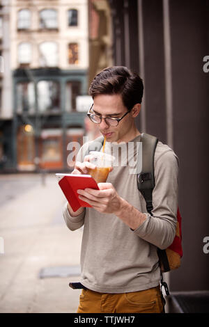 Man drinking juice while using tablet computer Stock Photo
