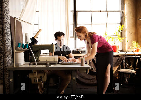 Fashion designers discussing over fabric at workshop Stock Photo