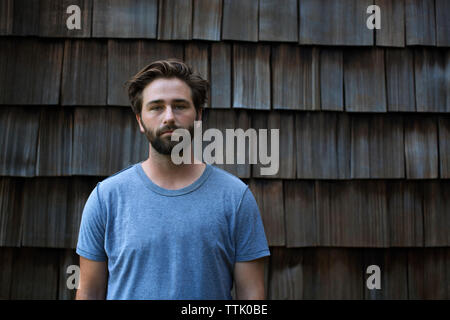 Portrait of man standing against wooden shingles Stock Photo