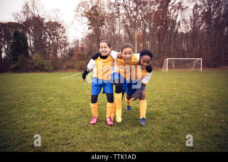 Full length of soccer players enjoying on playing field against trees Stock Photo