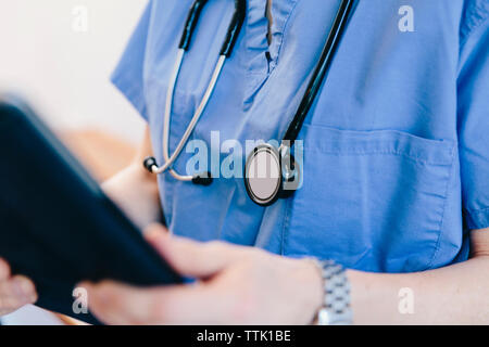 Midsection of female doctor using tablet computer in hospital Stock Photo