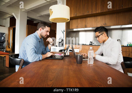 business partners using laptop computer on table at creative office Stock Photo