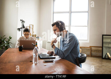 business colleagues using laptop computer at creative office Stock Photo