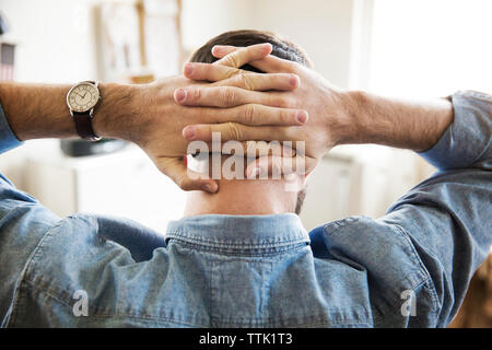 Rear view of businessman hands clasped in creative office Stock Photo