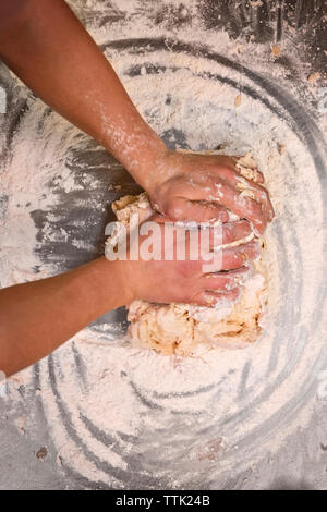 Cropped image of chef's hands kneading dough at commercial kitchen Stock Photo