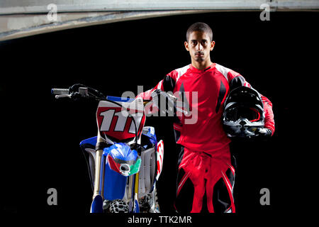 Portrait of man standing with motorcycle Stock Photo