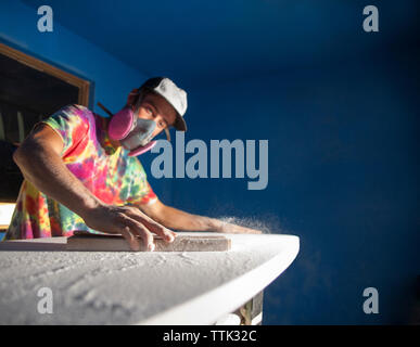 Man making surfboard in workshop Stock Photo
