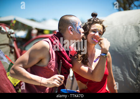 Cheerful man and woman with face paints enjoying during traditional event Stock Photo