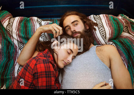 Overhead view of woman sleeping with thoughtful man in pick-up truck Stock Photo