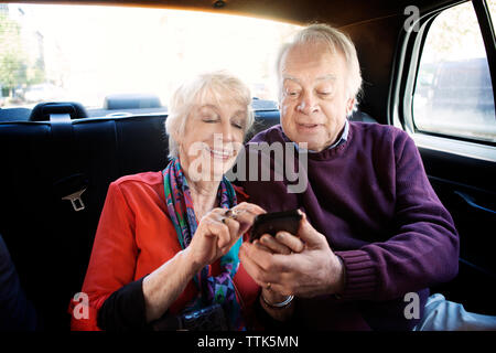 Senior couple using smart phone in car Stock Photo