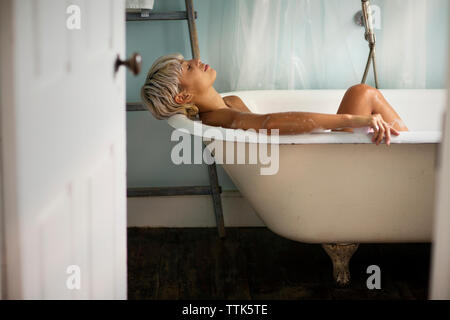 Side view of woman relaxing in bathtub Stock Photo