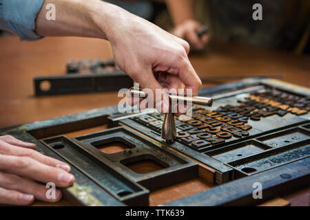 Cropped image of worker using quoin key on letterpress in workshop Stock Photo
