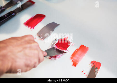 Cropped image of hand mixing colors on table at workshop Stock Photo