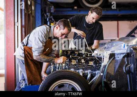 Mechanics repairing car engine in auto repair shop Stock Photo