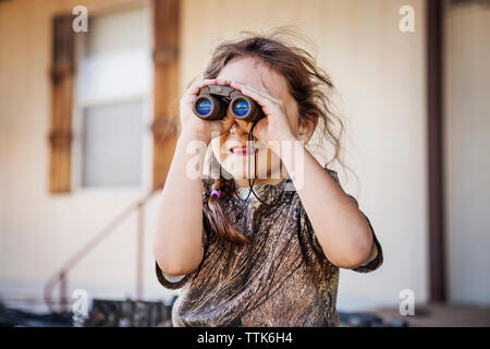 Girl looking through binoculars Stock Photo