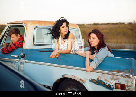 Thoughtful friends leaning out while traveling in pick-up truck Stock Photo