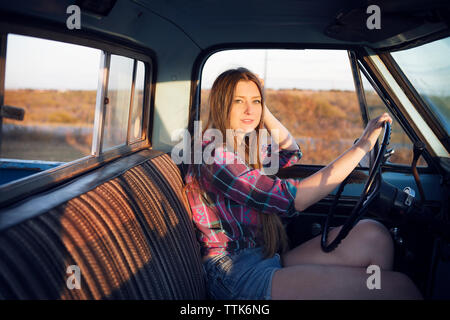 Portrait of woman with hand on steering wheel in pick-up truck Stock Photo