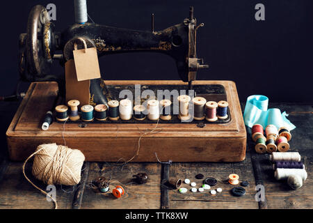 Thread reels on sewing machine at table Stock Photo