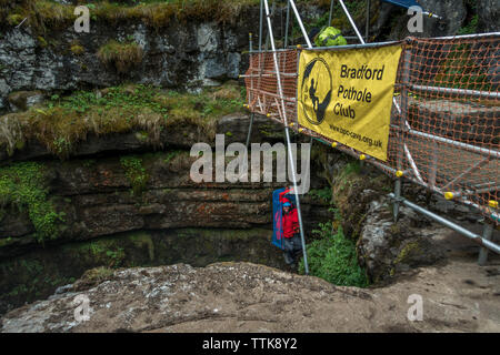 A tourist is winched into Gaping Gill by the Bradford Pothole Club, one of the largest known underground chambers in Britain. The cavern is only open Stock Photo