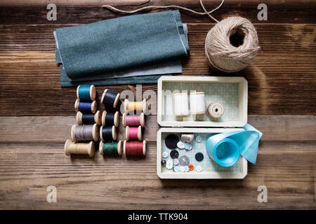 Overhead view of fabric with sewing equipment on table Stock Photo