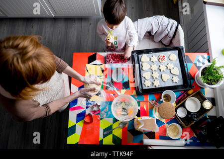 Overhead view of mother and son making cookies at home Stock Photo