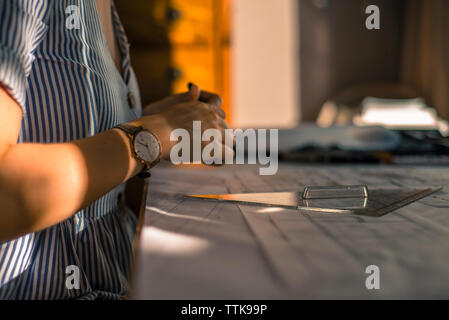Young woman drawing architect plans on desk Stock Photo