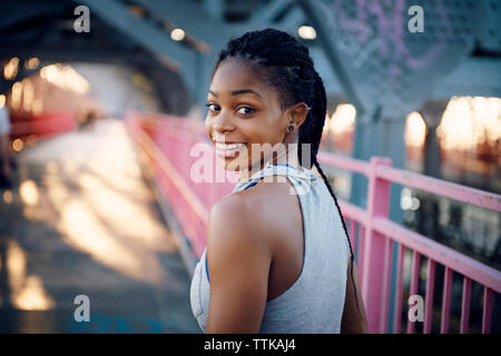 Portrait of smiling woman standing on bridge Stock Photo