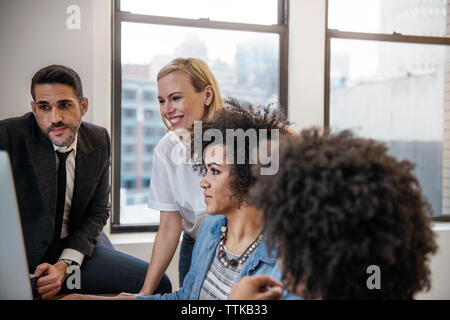 Happy colleagues working on computer in office Stock Photo