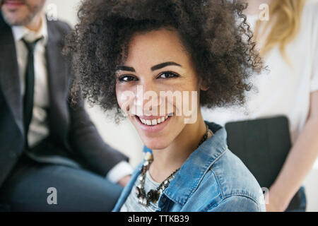 Portrait of happy confident businesswoman by colleagues in office Stock Photo