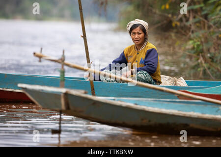 Local woman sitting in a boat on the Nam Ou River at Done Khoun, near Nong Khiaw, Muang Ngoi District, Luang Prabang Province, Northern Laos, Laos, So Stock Photo