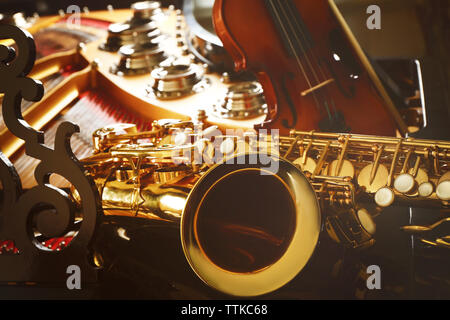 Violin and saxophone lying on piano, close up Stock Photo